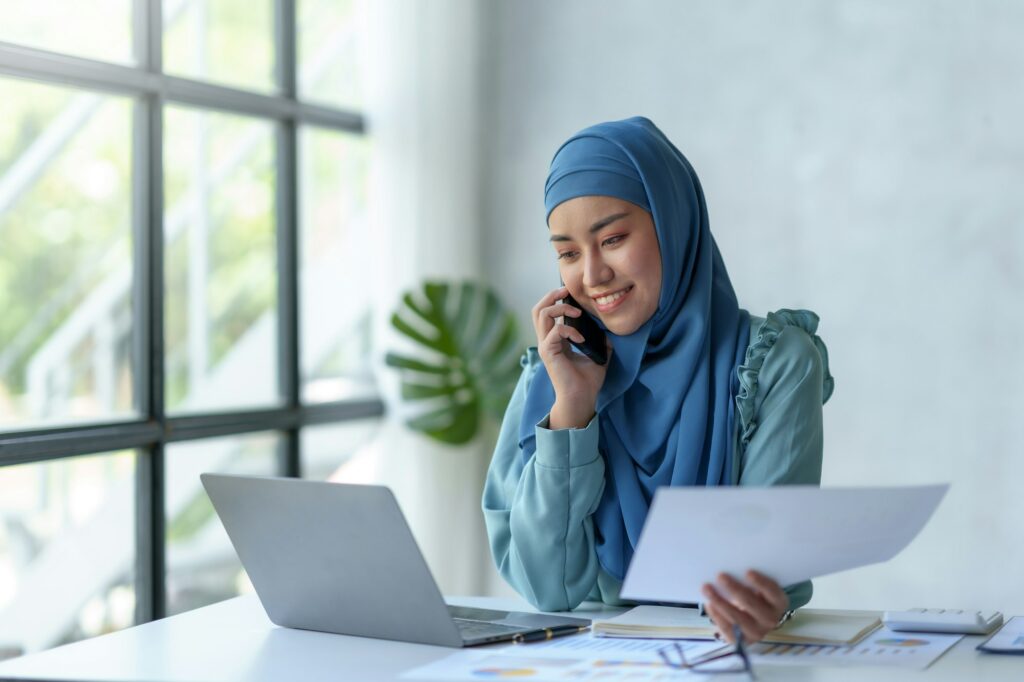 Beautiful Muslim businesswoman talking on the phone in the office.