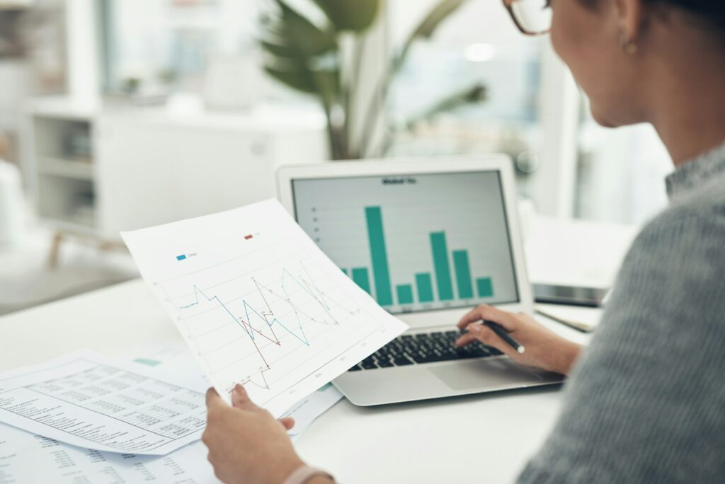 Closeup shot of an unrecognisable businesswoman analysing graphs in an office